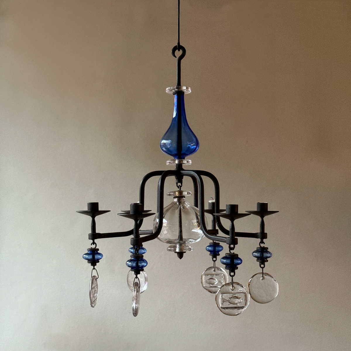 A 1960s blue chandelier by Erik Höglund, featuring pressed glass fish details and an iron frame. Crafted for Boda in Sweden, this vintage piece is available from Sigmar and exemplifies mid-century Scandinavian design.