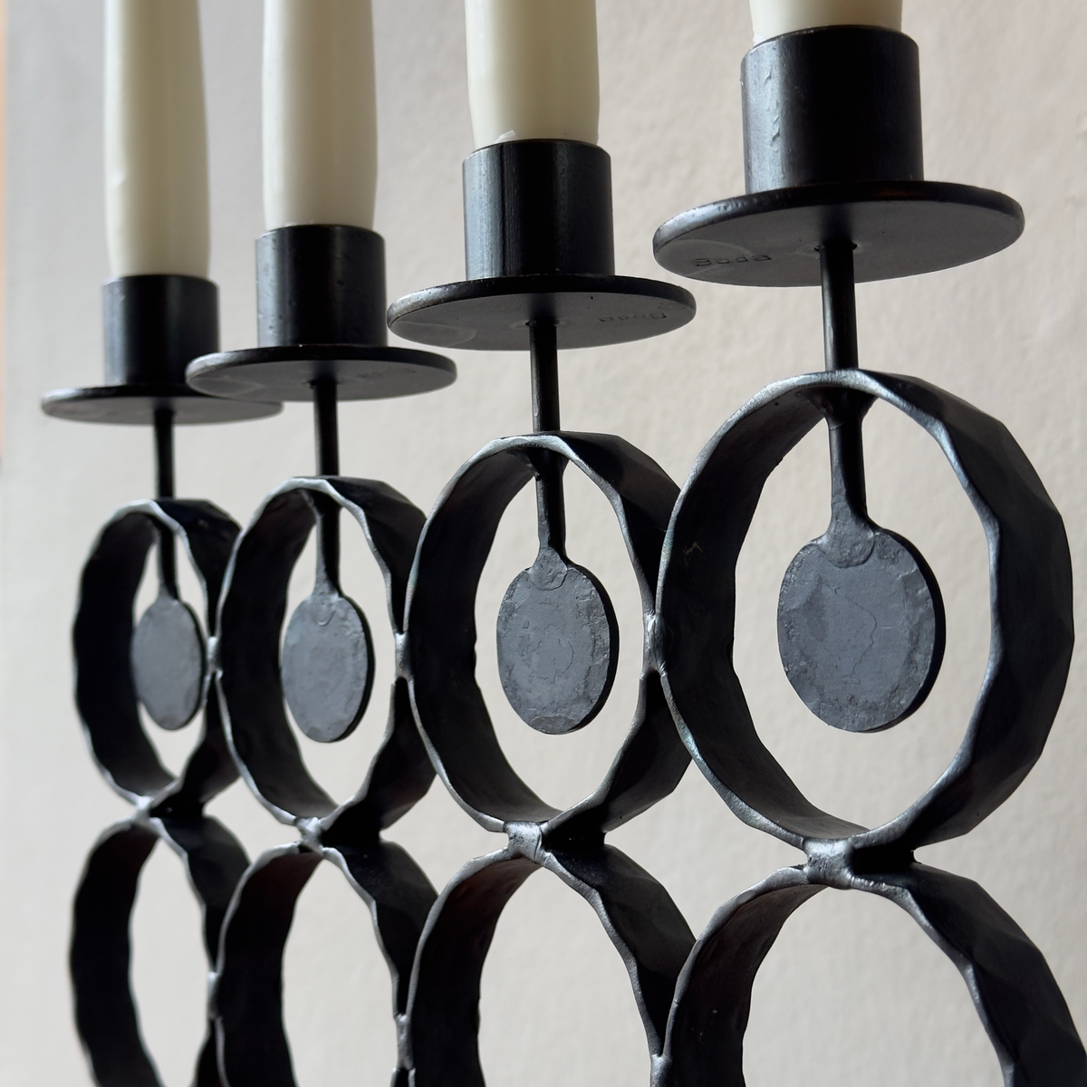 A vintage 1960s iron candelabrum by Bertil Vallien, made in Sweden for Boda Smide. This mid-century piece reflects Vallien's organic design style and the influence of Swedish folk art.