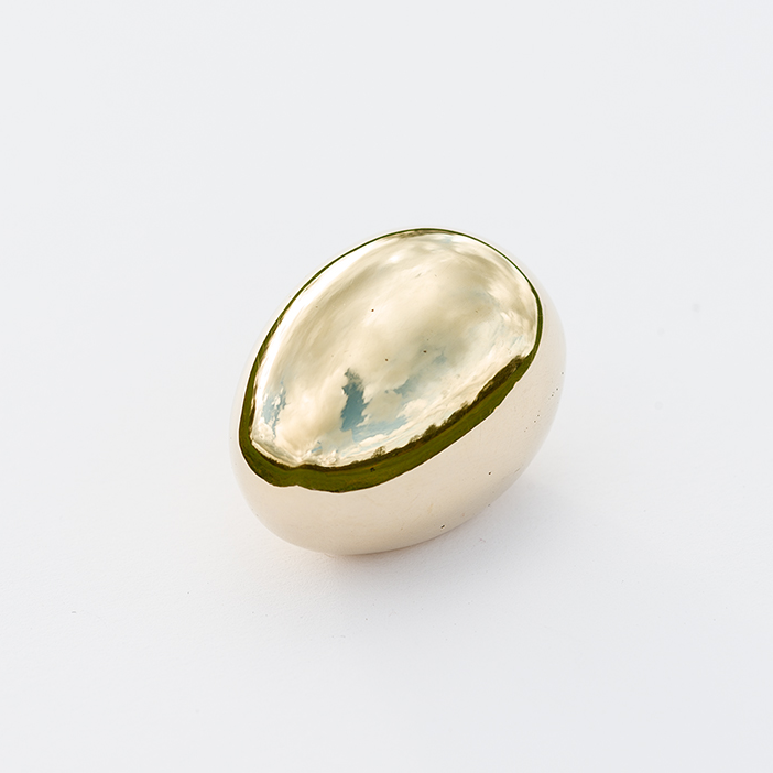 An egg-shaped paperweight designed by Carl Auböck II, made of solid cast brass in Vienna. This piece exemplifies modernist design with its smooth, minimalist form.