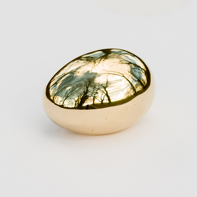 An egg-shaped paperweight designed by Carl Auböck II, made of solid cast brass in Vienna. This piece exemplifies modernist design with its smooth, minimalist form.