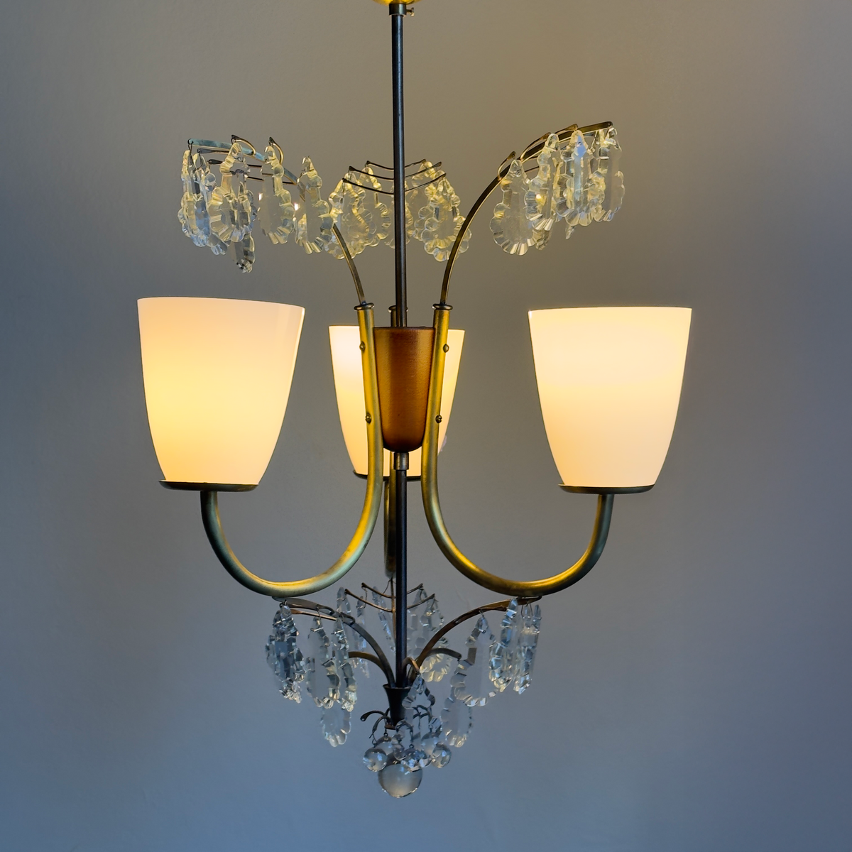 A 1940s crystal-cut chandelier by Lisa Johansson-Pape, featuring a three-light design. Produced by Stockmann Orno in Finland, this elegant piece showcases Scandinavian craftsmanship and timeless design.