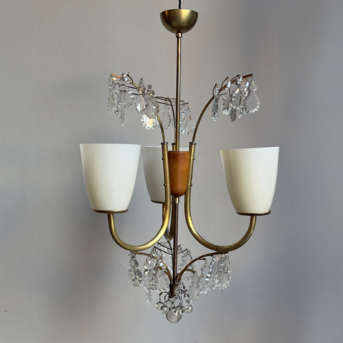 A 1940s crystal-cut chandelier by Lisa Johansson-Pape, featuring a three-light design. Produced by Stockmann Orno in Finland, this elegant piece showcases Scandinavian craftsmanship and timeless design.