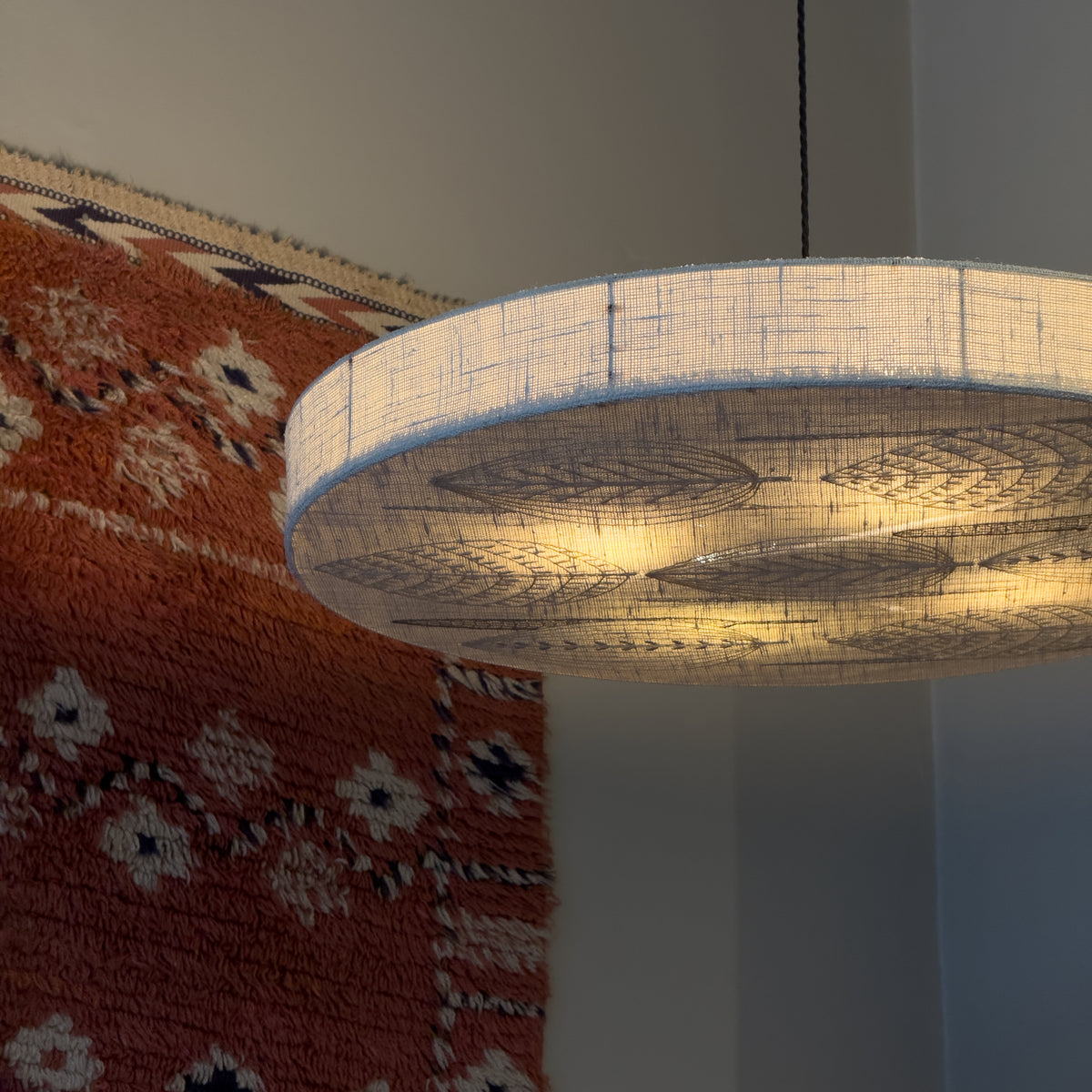 Sigmar London. Designed in the 1970s, the lamp emits a soft, diffused light through delicate stitched patterns, blending textile craftsmanship with functional lighting, from Sweden.