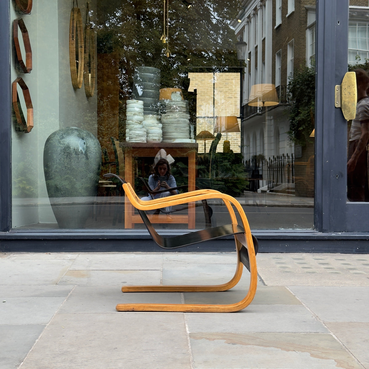 An Alvar Aalto-designed Finmar 31 armchair, featuring black curved plywood. This armchair is an iconic example of Finnish modernism, showcased by Sigmar Design Gallery in London.