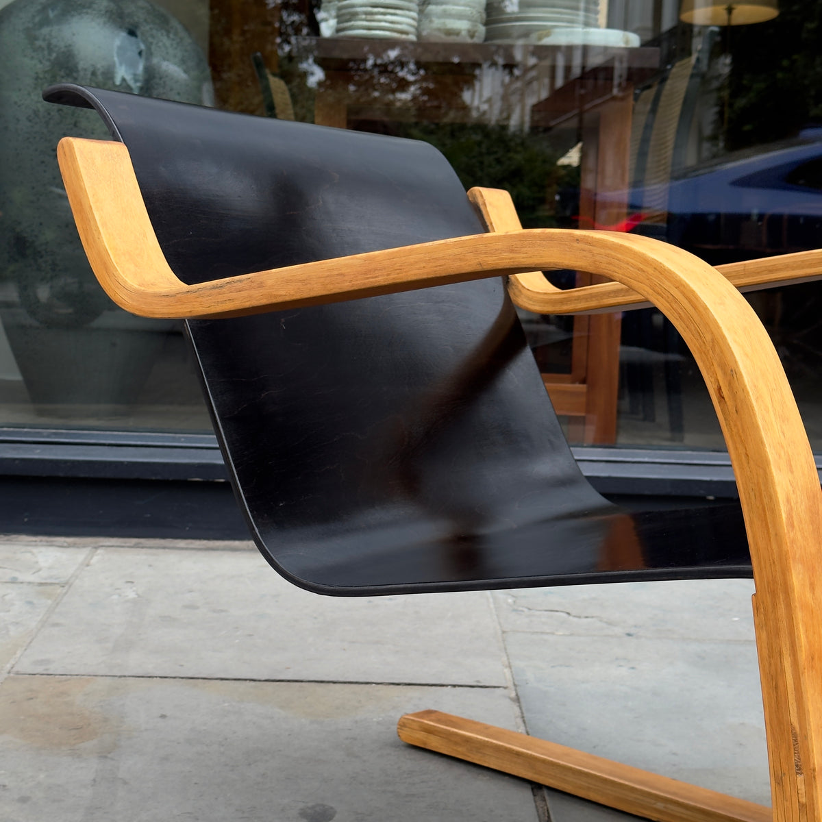 An Alvar Aalto-designed Finmar 31 armchair, featuring black curved plywood. This armchair is an iconic example of Finnish modernism, showcased by Sigmar Design Gallery in London.