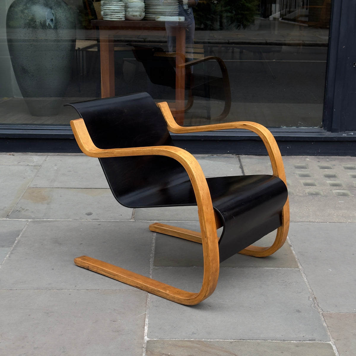 An Alvar Aalto-designed Finmar 31 armchair, featuring black curved plywood. This armchair is an iconic example of Finnish modernism, showcased by Sigmar Design Gallery in London.