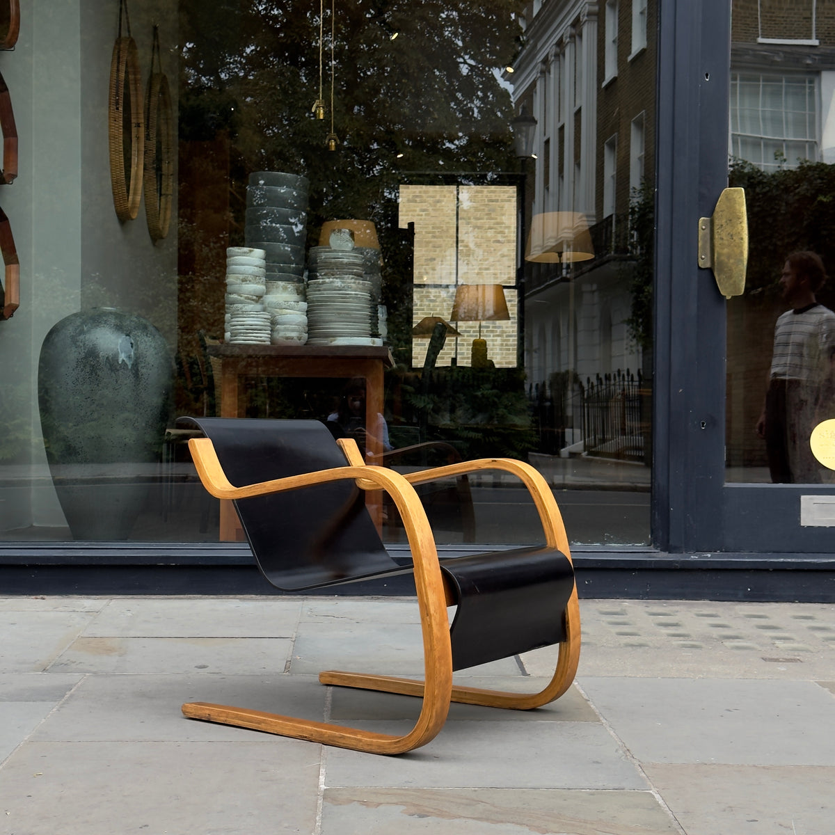 An Alvar Aalto-designed Finmar 31 armchair, featuring black curved plywood. This armchair is an iconic example of Finnish modernism, showcased by Sigmar Design Gallery in London.