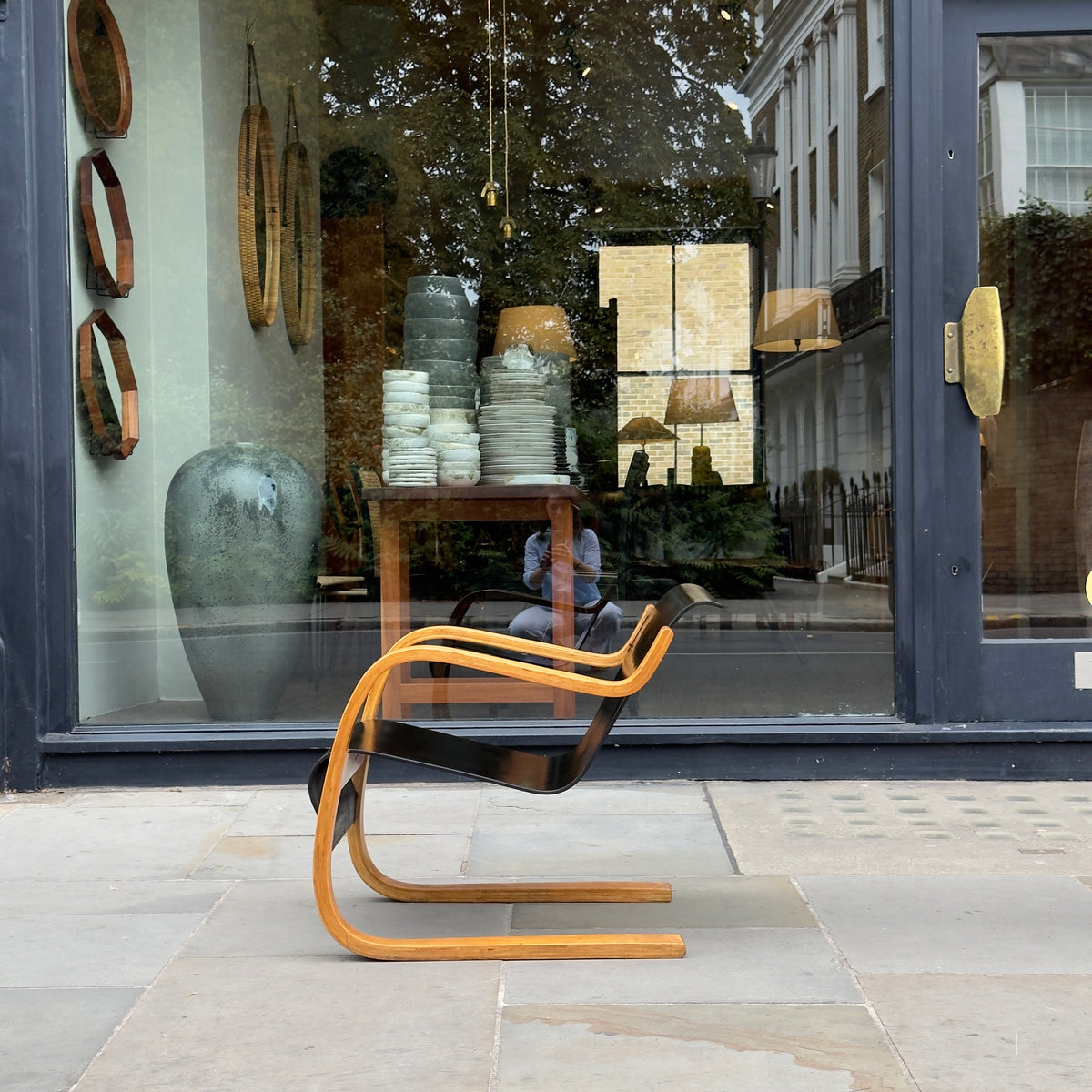 An Alvar Aalto-designed Finmar 31 armchair, featuring black curved plywood. This armchair is an iconic example of Finnish modernism, showcased by Sigmar Design Gallery in London.