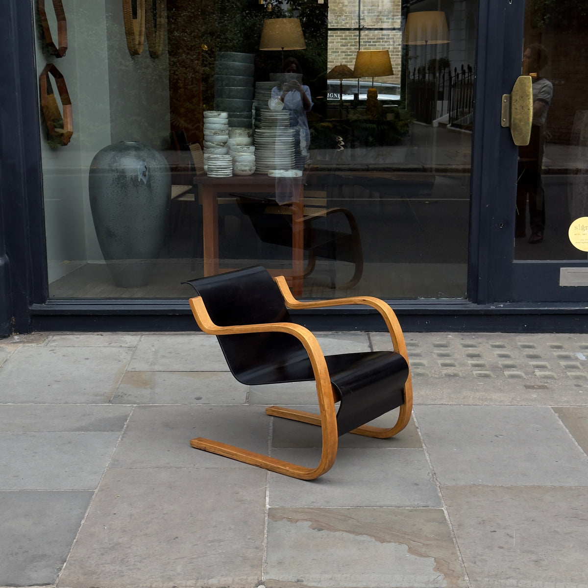 An Alvar Aalto-designed Finmar 31 armchair, featuring black curved plywood. This armchair is an iconic example of Finnish modernism, showcased by Sigmar Design Gallery in London.