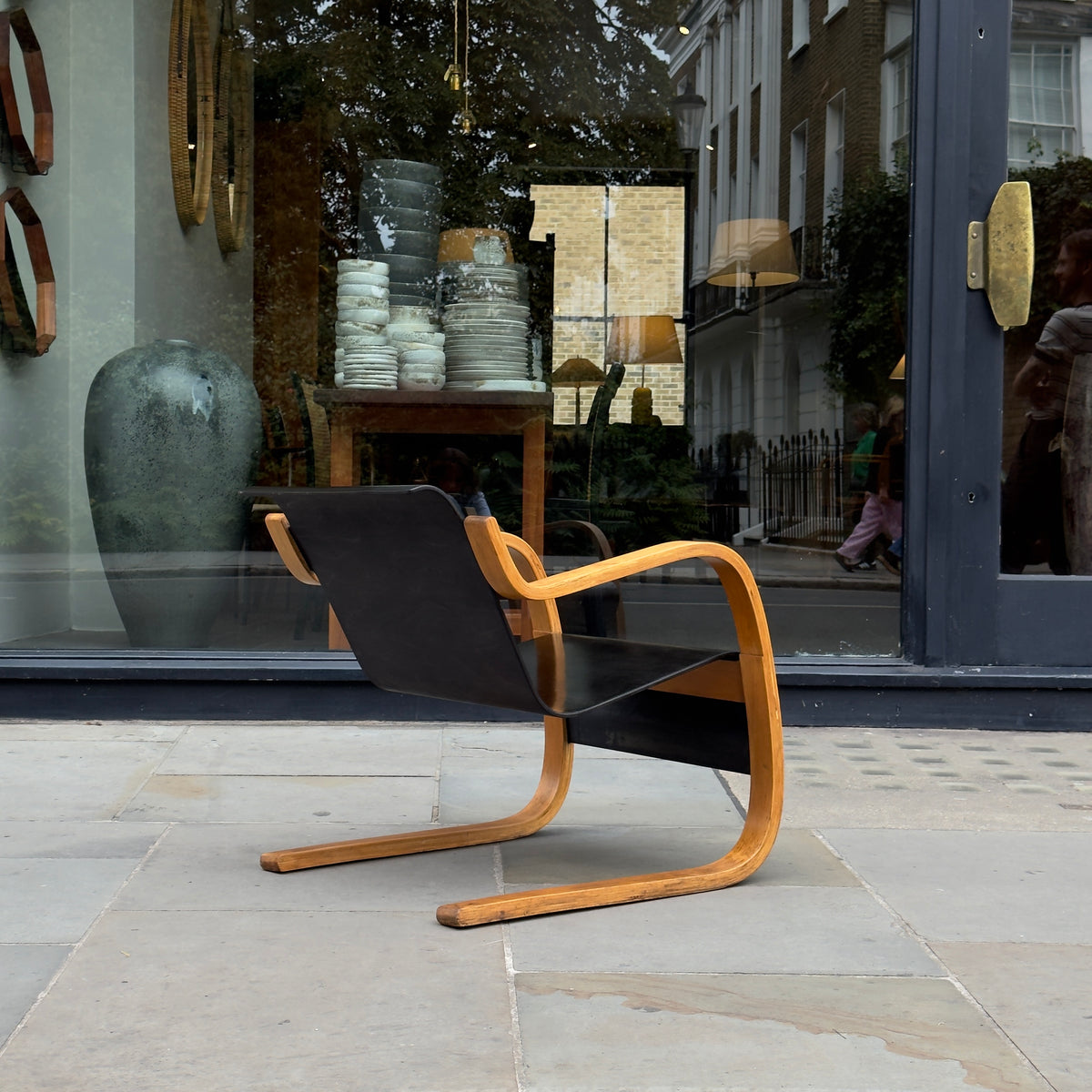 An Alvar Aalto-designed Finmar 31 armchair, featuring black curved plywood. This armchair is an iconic example of Finnish modernism, showcased by Sigmar Design Gallery in London.