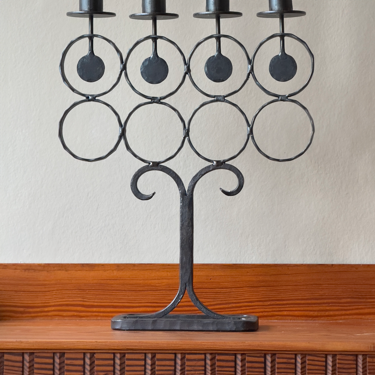 A vintage 1960s iron candelabrum by Bertil Vallien, made in Sweden for Boda Smide. This mid-century piece reflects Vallien's organic design style and the influence of Swedish folk art.