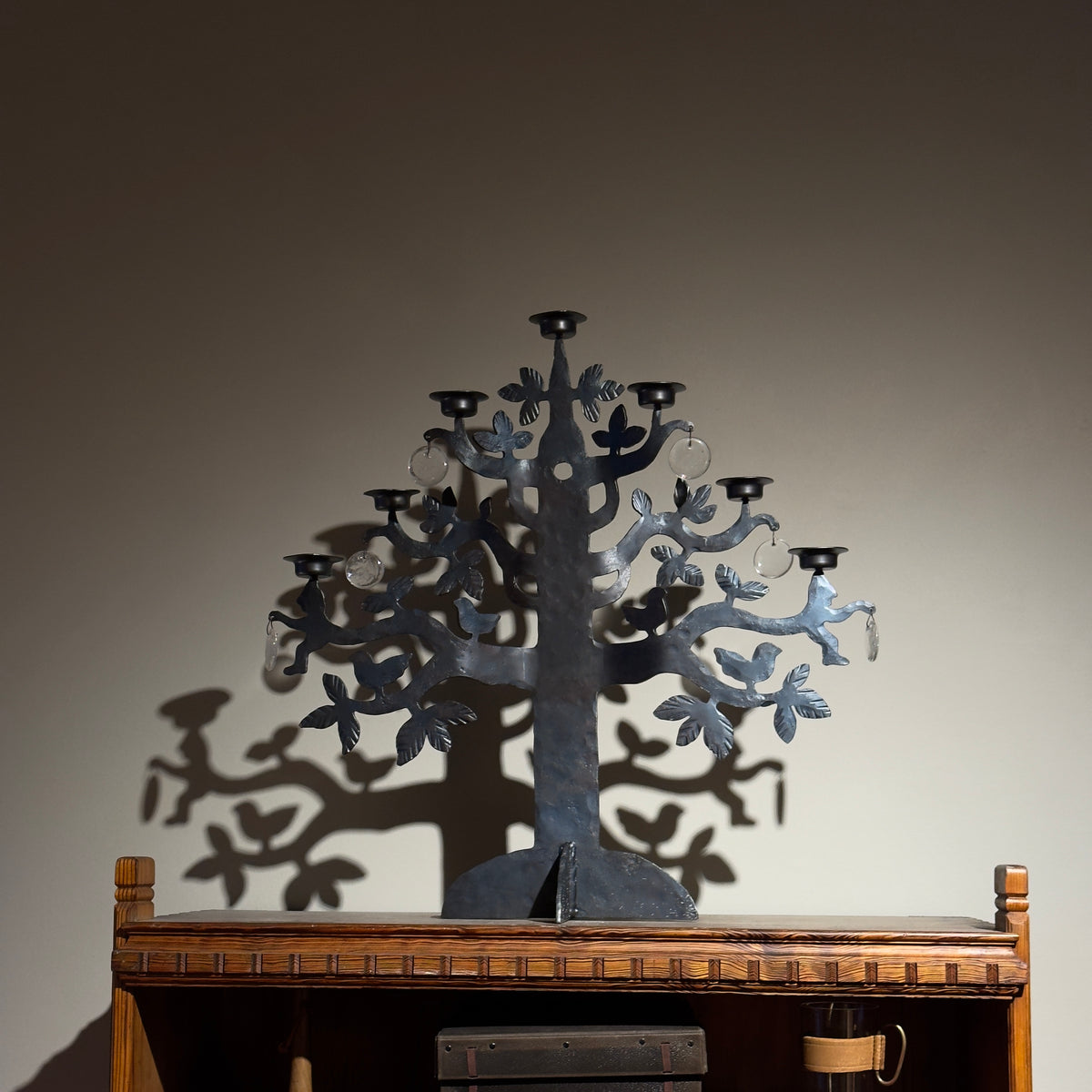 A 1970s 'Tree of Life' wrought iron standing candelabrum chandelier by Bertil Vallien for Boda Smide, Sweden. This vintage piece combines iron and glass elements, showcasing Vallien's artistic vision and Swedish craftsmanship, available from Sigmar.