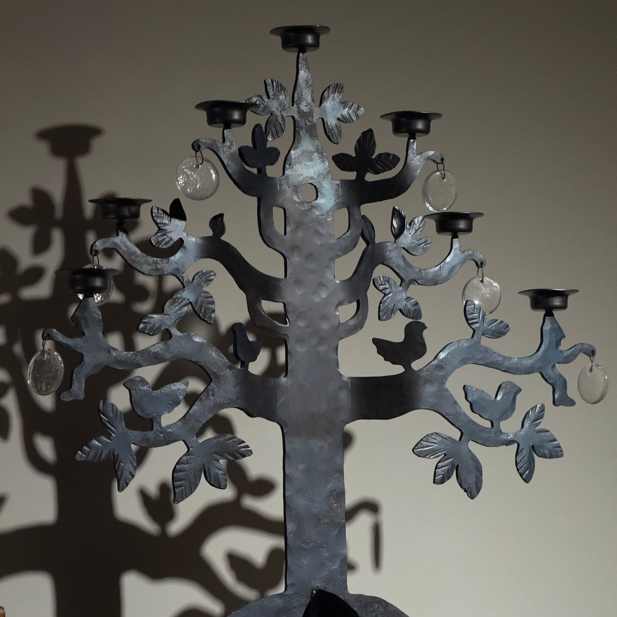 A 1970s 'Tree of Life' wrought iron standing candelabrum chandelier by Bertil Vallien for Boda Smide, Sweden. This vintage piece combines iron and glass elements, showcasing Vallien's artistic vision and Swedish craftsmanship, available from Sigmar.