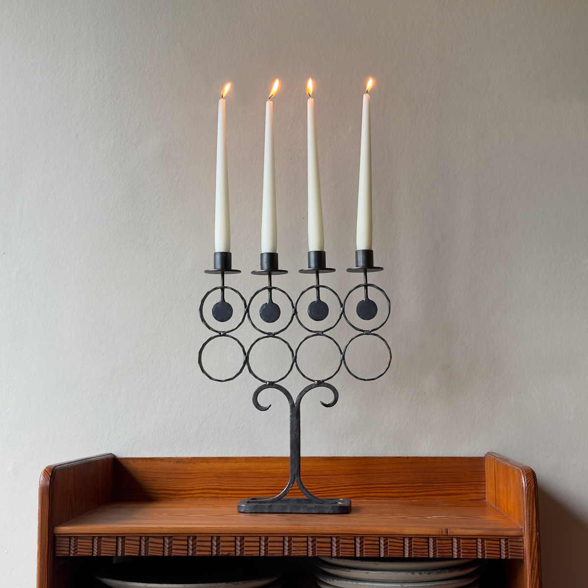 A vintage 1960s iron candelabrum by Bertil Vallien, made in Sweden for Boda Smide. This mid-century piece reflects Vallien's organic design style and the influence of Swedish folk art.