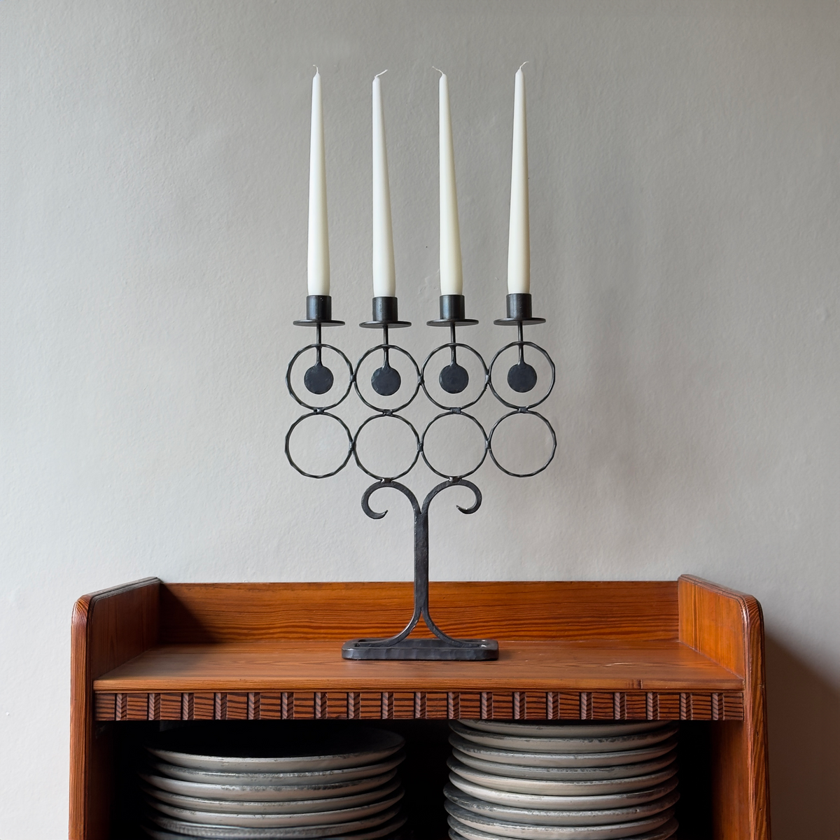 A vintage 1960s iron candelabrum by Bertil Vallien, made in Sweden for Boda Smide. This mid-century piece reflects Vallien's organic design style and the influence of Swedish folk art.