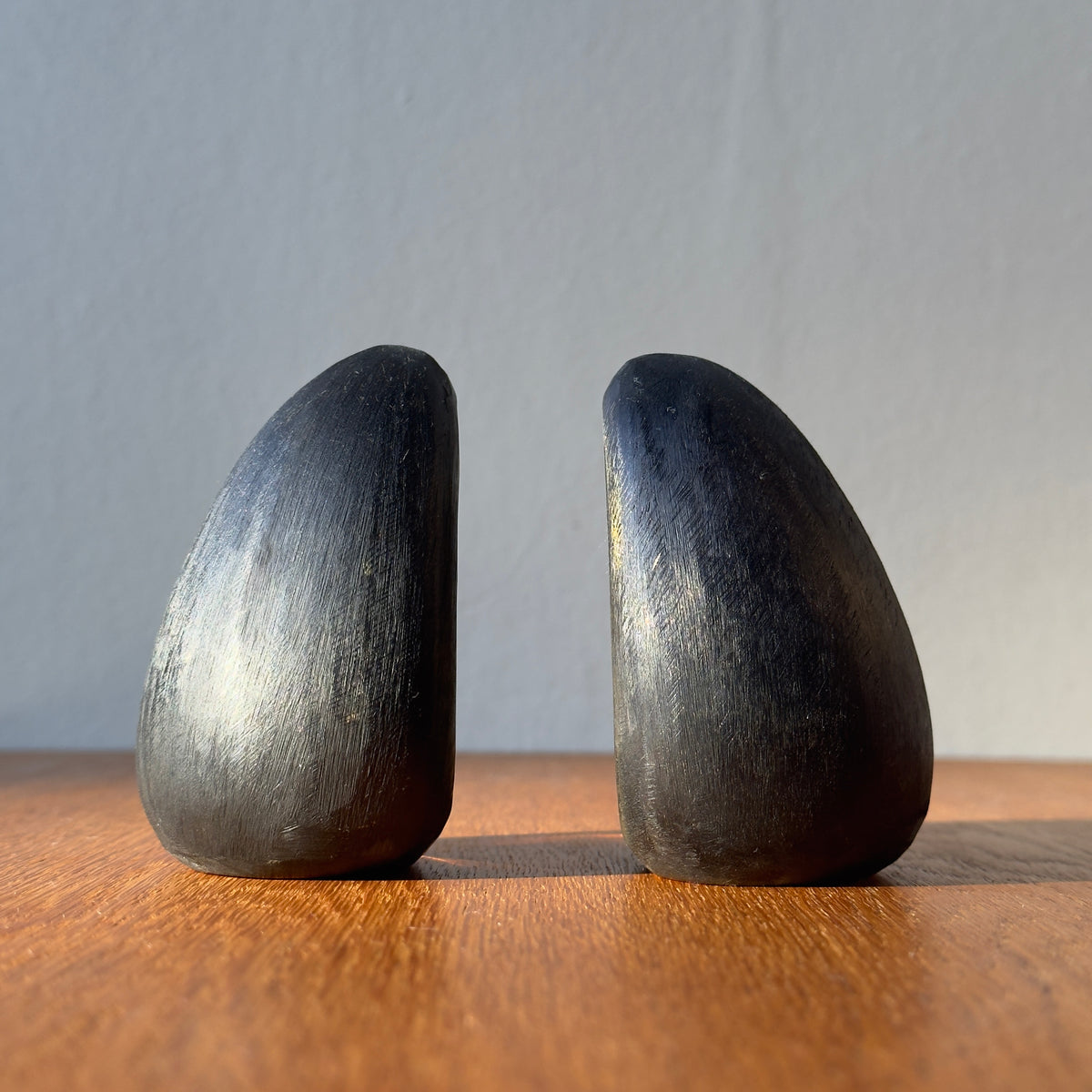 A pair of brass drop-shaped bookends by Carl Auböck, crafted in the Werkstätte Auböck workshop and available at Sigmar London. These midcentury pieces highlight Austrian modernist design and exceptional craftsmanship.