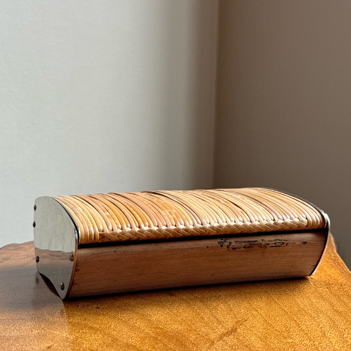 A vintage 1950s cigarette box by Carl Auböck, featuring a walnut body with chrome-plated brass ends. This original piece exemplifies mid-century Austrian design and craftsmanship.