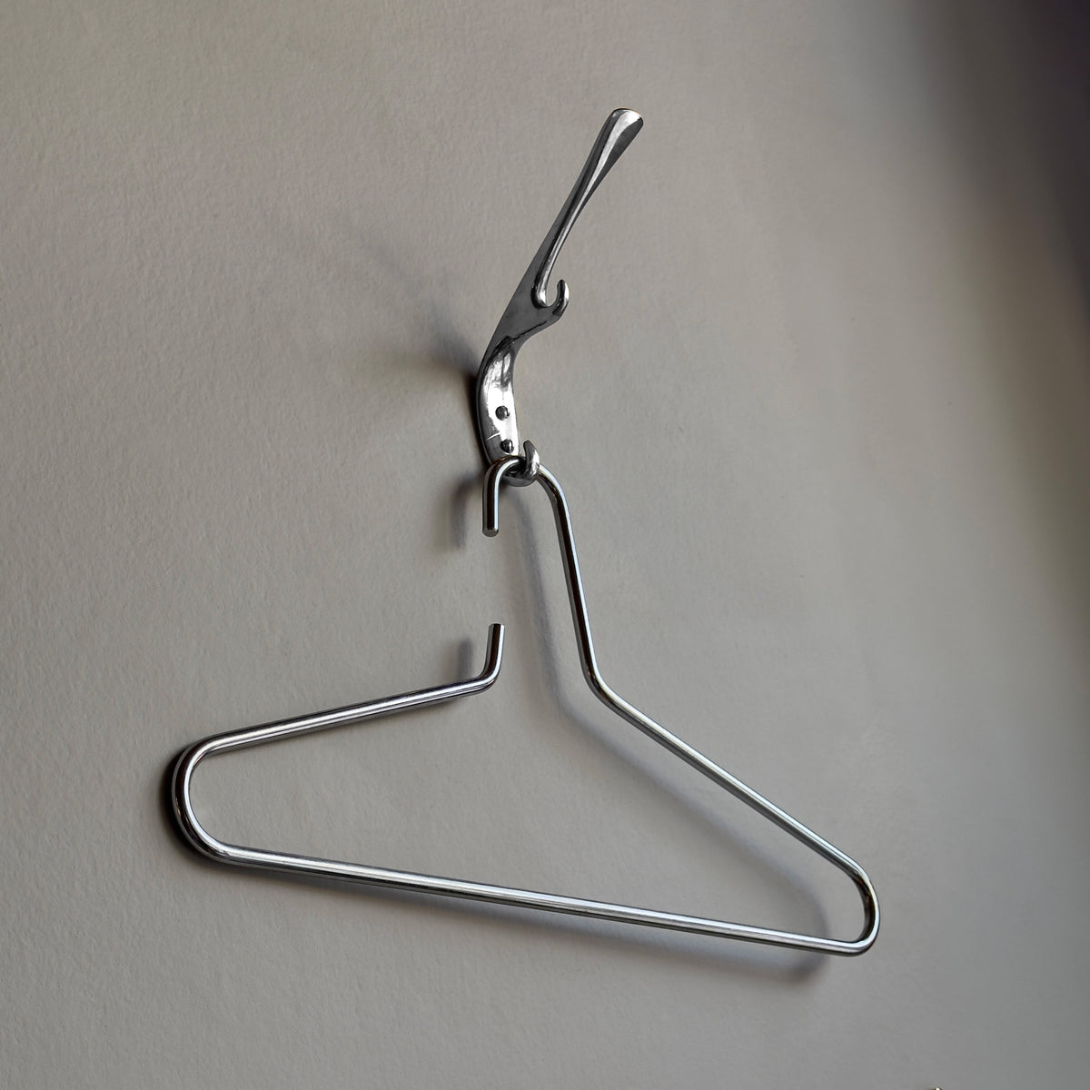 Nickel-plated brass coat hanger by Carl Auböck III, featured in Vienna shop, INDIE, in the 1960s, an architectural project of the 3rd Carl Aubock. This modernist and minimal design exemplifies Auböck’s craftsmanship, blending functionality with sculptural elegance.