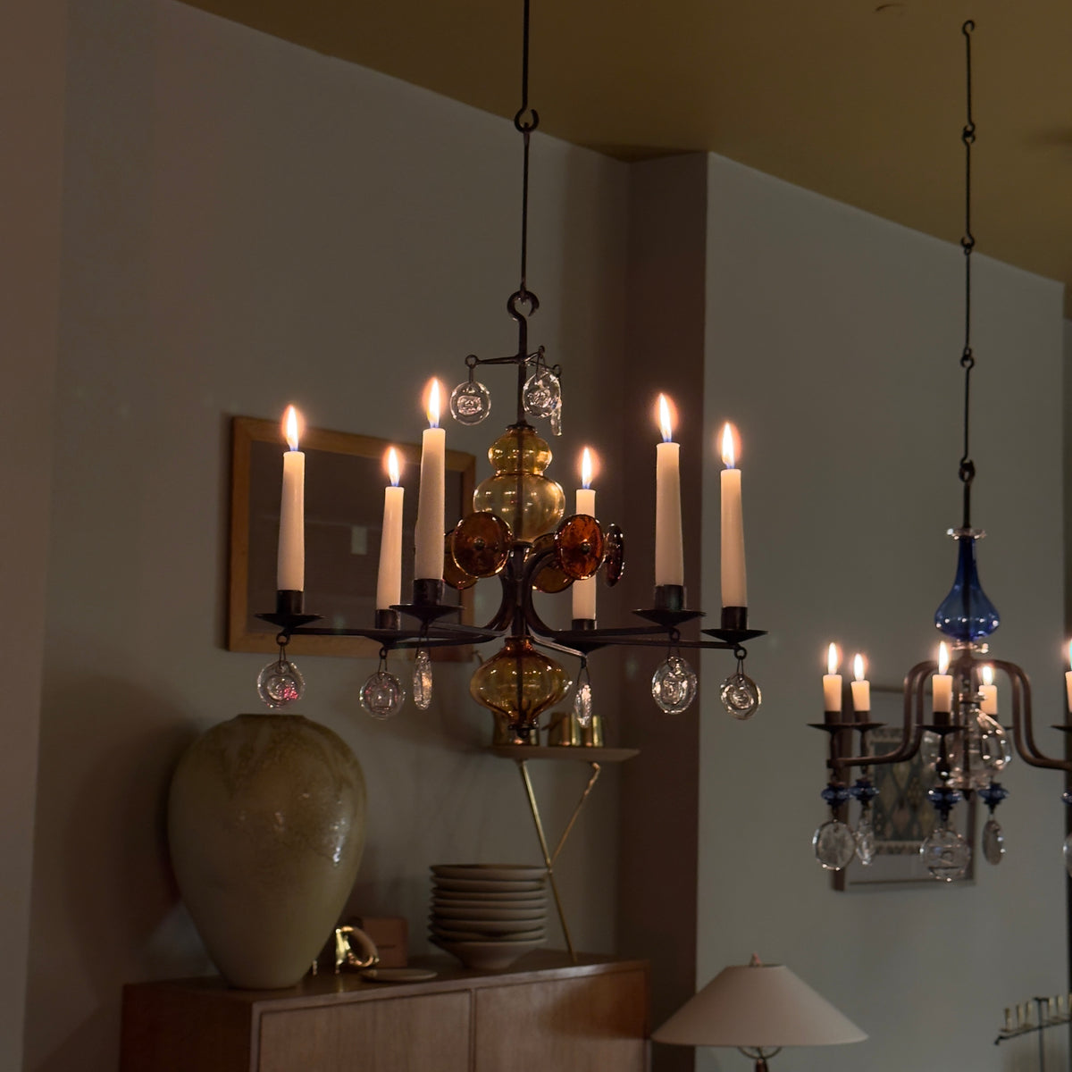 A 1960s amber chandelier by Erik Höglund, featuring pressed glass face details and an iron frame. Crafted for Boda in Sweden, this vintage piece is available from Sigmar and exemplifies mid-century Scandinavian design.