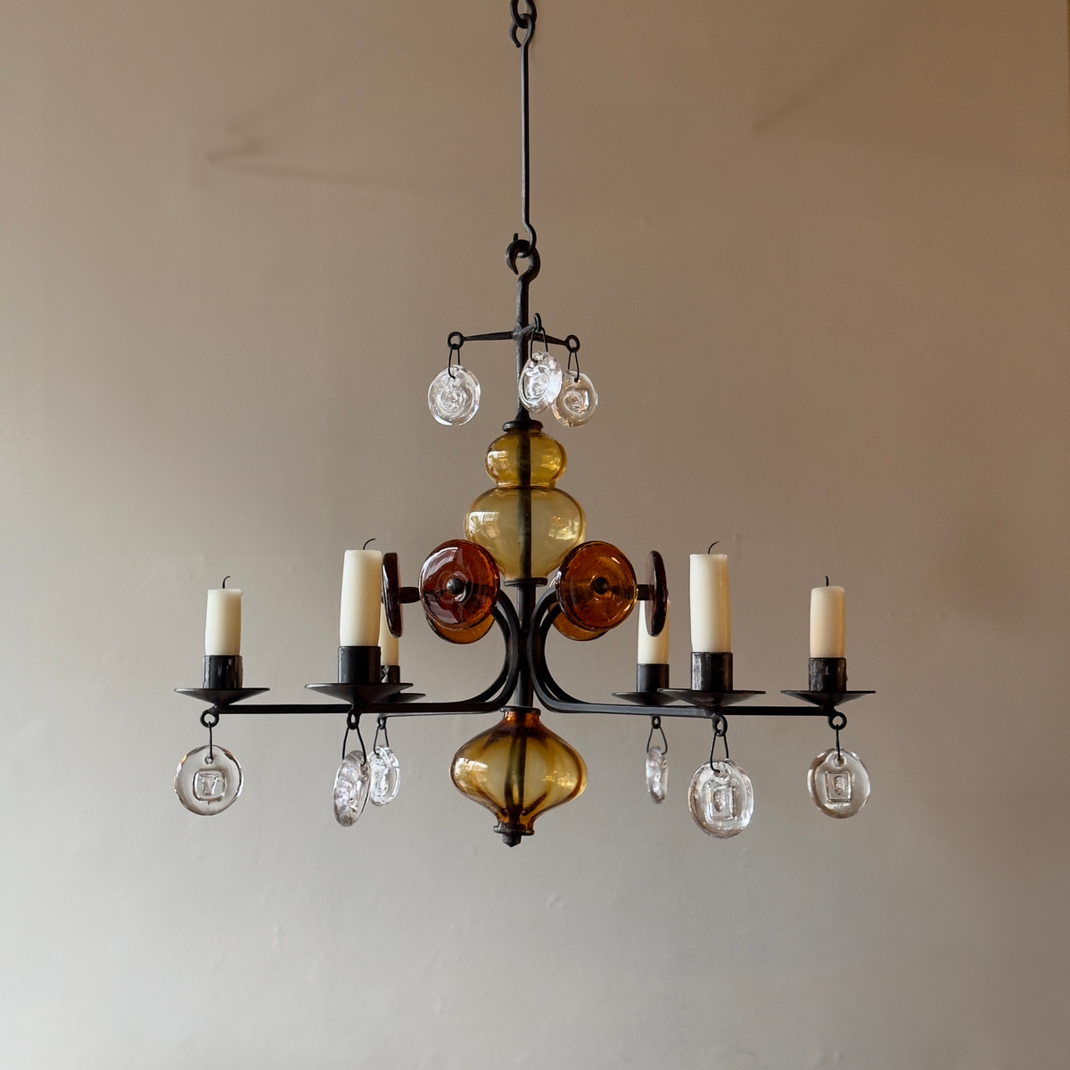 A 1960s amber chandelier by Erik Höglund, featuring pressed glass face details and an iron frame. Crafted for Boda in Sweden, this vintage piece is available from Sigmar and exemplifies mid-century Scandinavian design.