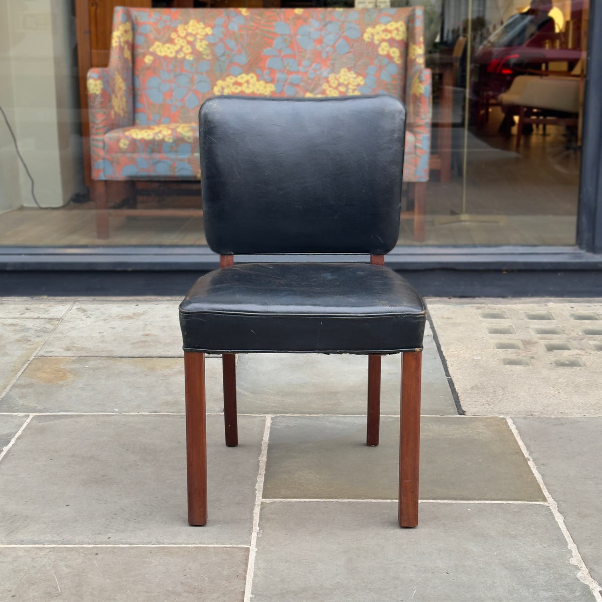 A Normina vintage armchair featuring black leather upholstery and a midcentury design. This elegant piece combines sleek lines with timeless comfort, reflecting the sophistication of mid-20th-century furniture design.