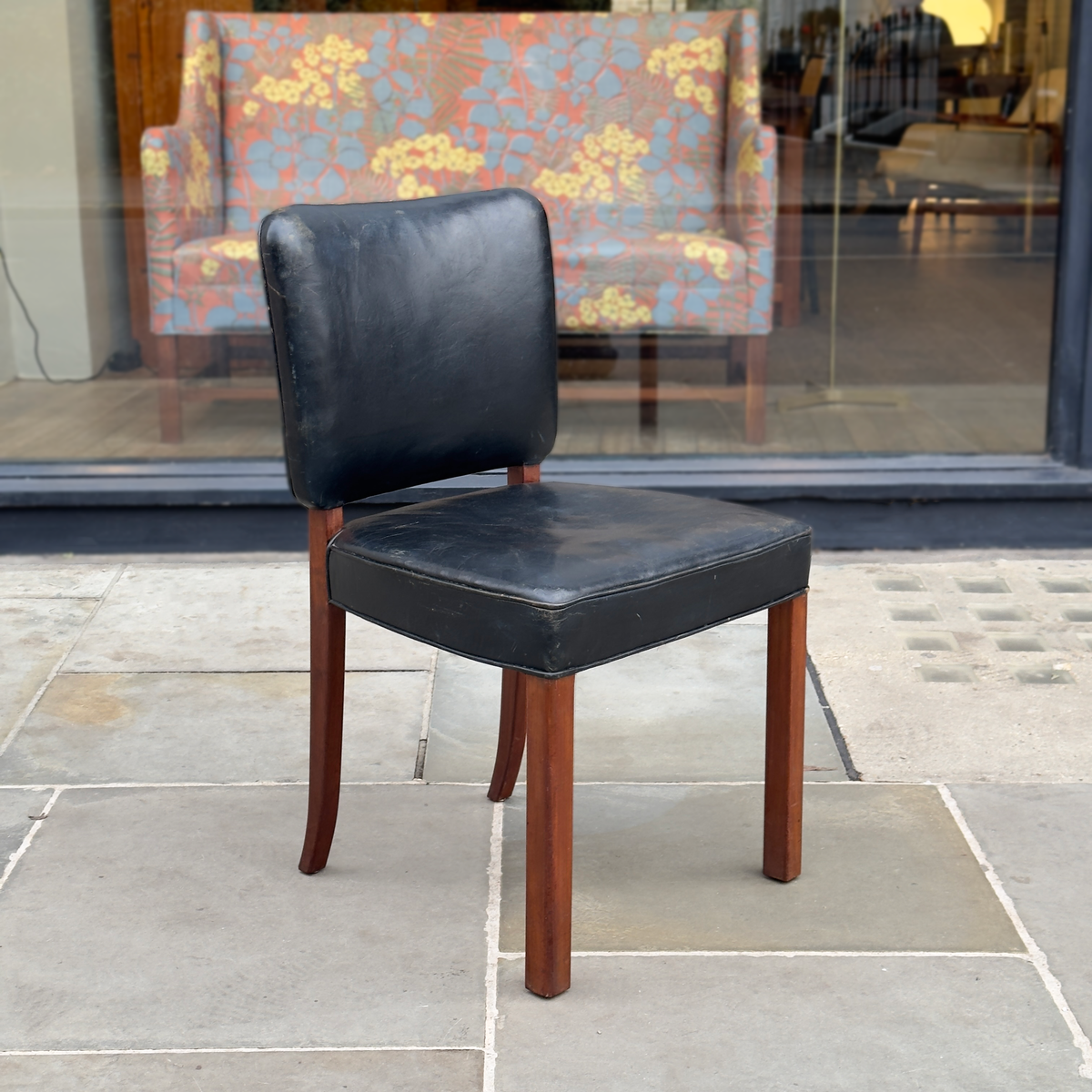 A Normina vintage armchair featuring black leather upholstery and a midcentury design. This elegant piece combines sleek lines with timeless comfort, reflecting the sophistication of mid-20th-century furniture design.