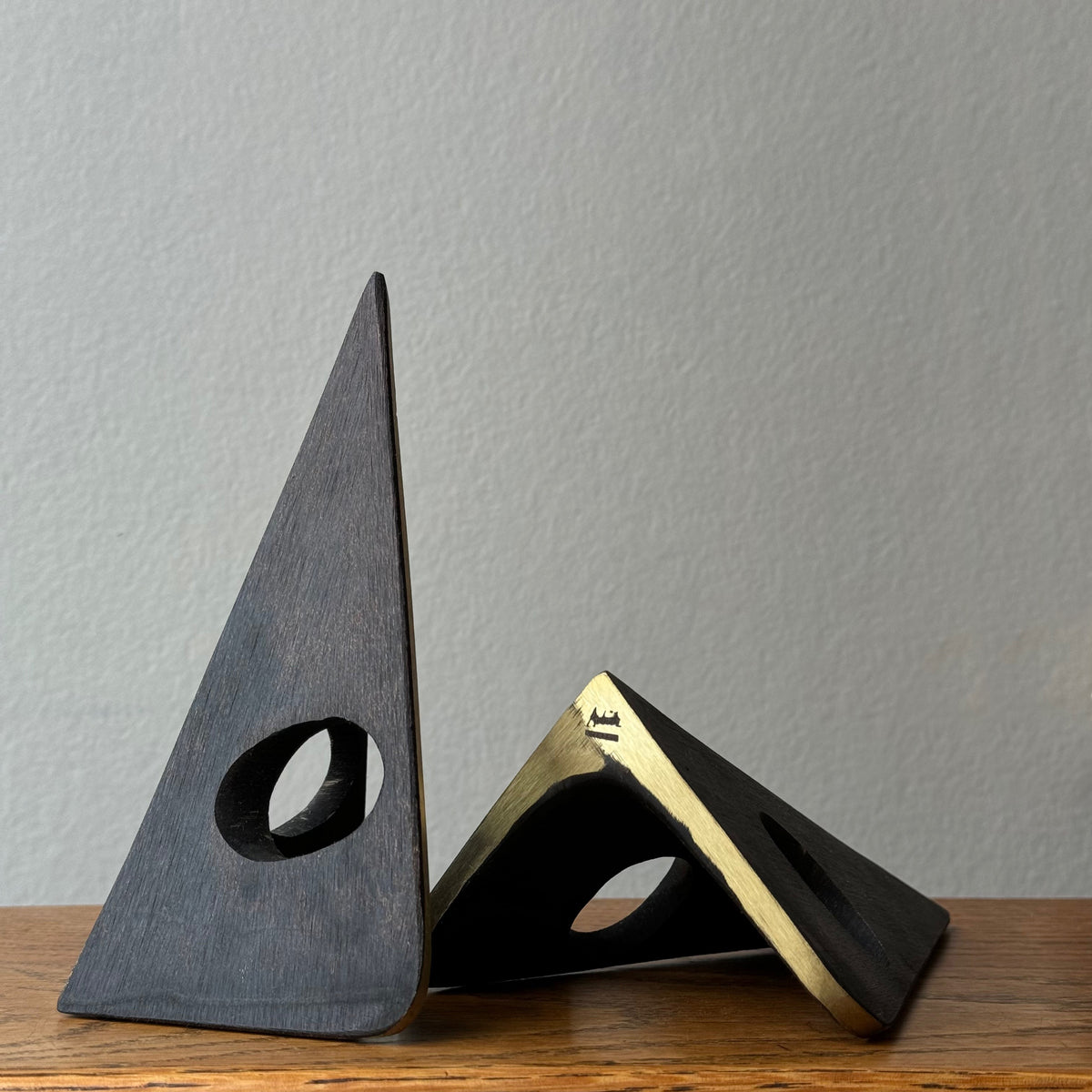 A solid cast brass bookend named 'Mask,' model 4100, designed by Carl Auböck. Based on a 1950s design, this piece is a sleek home accessory emblematic of modernist design.