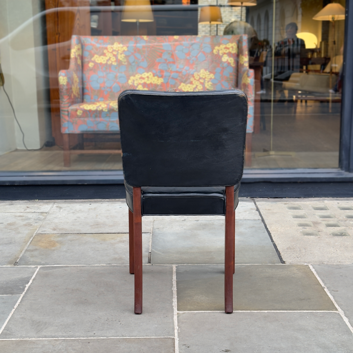 A Normina vintage armchair featuring black leather upholstery and a midcentury design. This elegant piece combines sleek lines with timeless comfort, reflecting the sophistication of mid-20th-century furniture design.