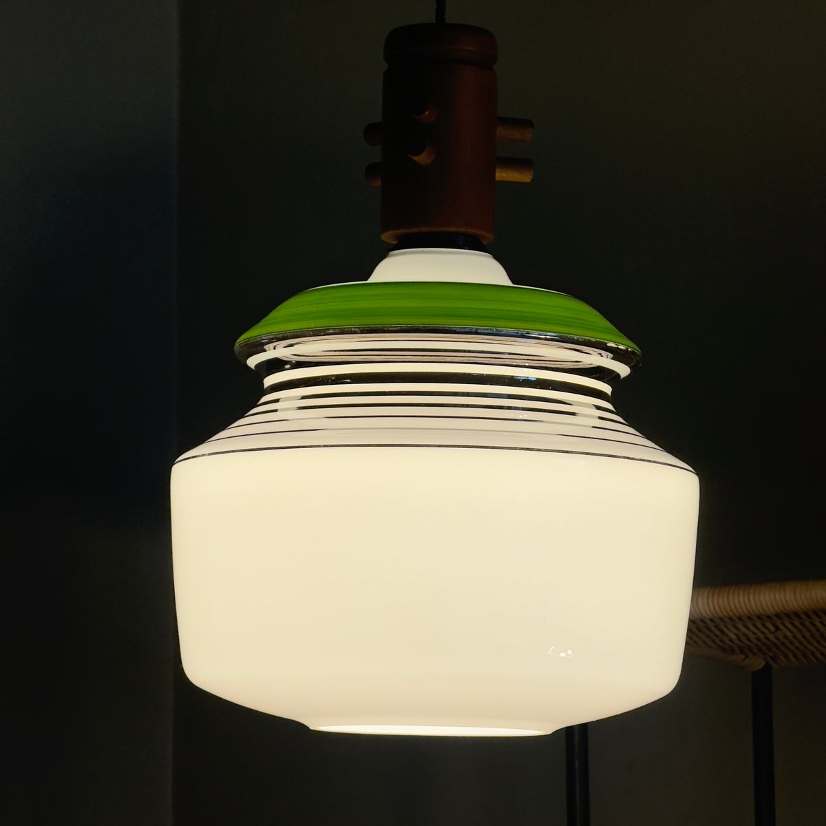 An opal glass pendant light with chrome accents, a green detail, and a wooden ceiling rose, produced by Slovakian manufacturer LIPTA. The design reflects the space-age aesthetics of the 1960s.