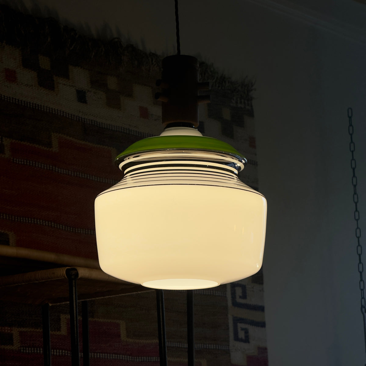 An opal glass pendant light with chrome accents, a green detail, and a wooden ceiling rose, produced by Slovakian manufacturer LIPTA. The design reflects the space-age aesthetics of the 1960s.