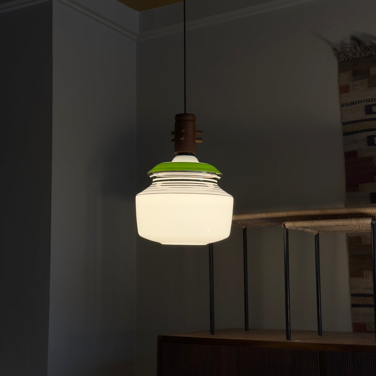 An opal glass pendant light with chrome accents, a green detail, and a wooden ceiling rose, produced by Slovakian manufacturer LIPTA. The design reflects the space-age aesthetics of the 1960s.