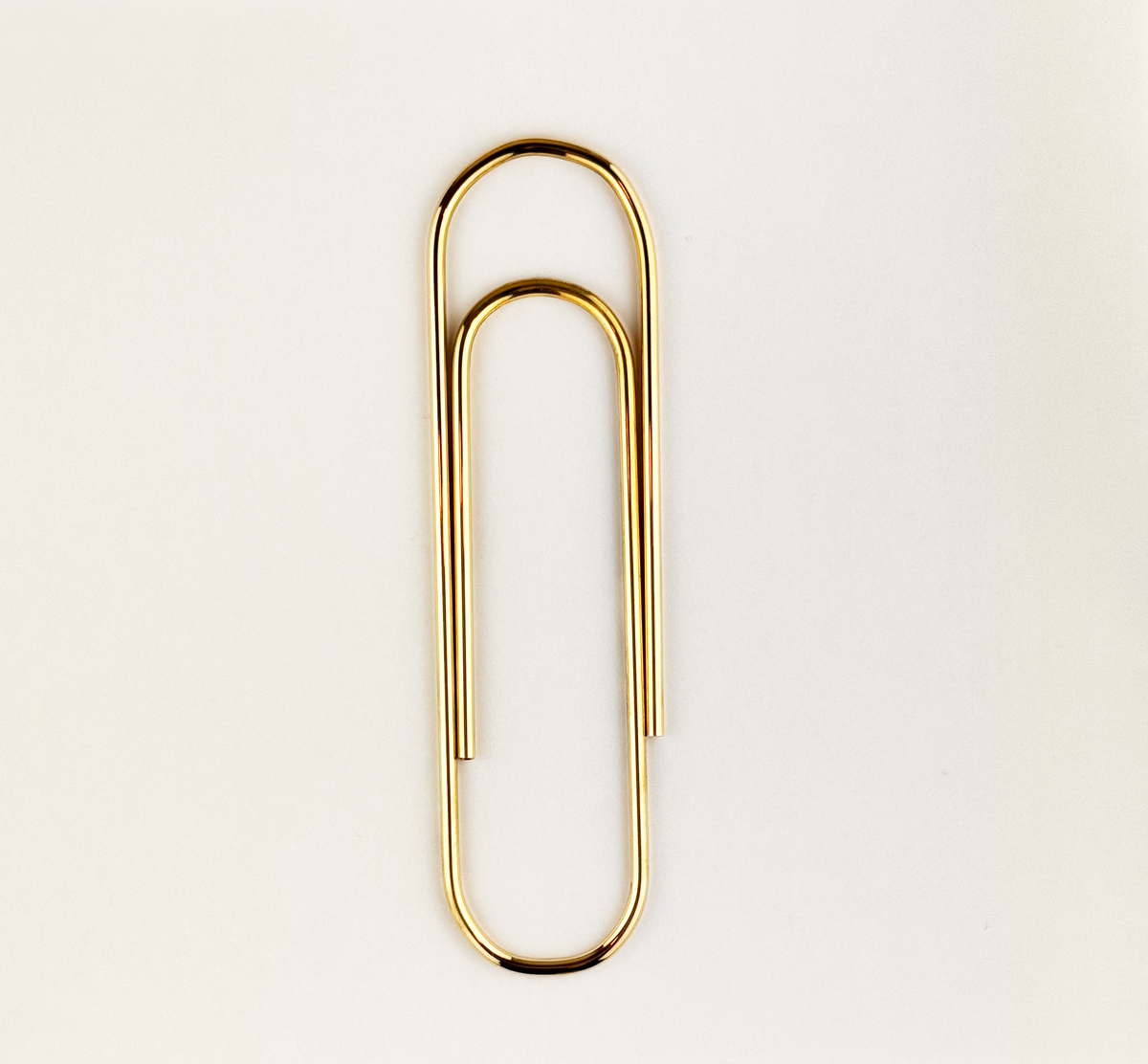 An oversized paper clip designed by Carl Auböck, crafted in brass and available at Sigmar London. This iconic midcentury design piece showcases the playful yet functional style of the Auböck workshop.