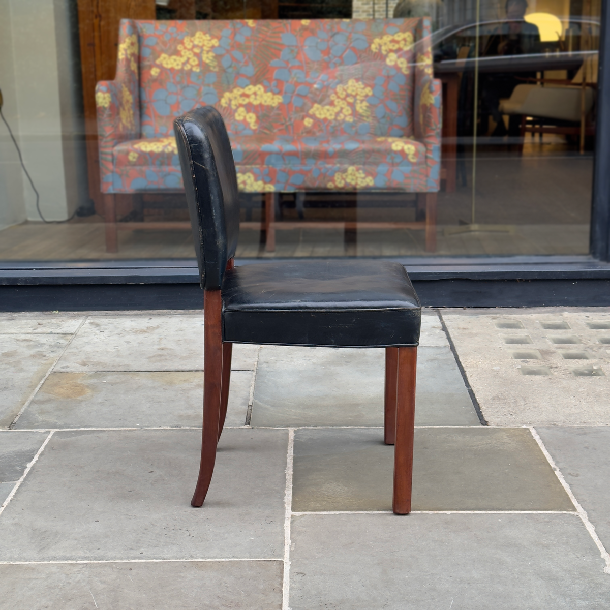 A Normina vintage armchair featuring black leather upholstery and a midcentury design. This elegant piece combines sleek lines with timeless comfort, reflecting the sophistication of mid-20th-century furniture design.