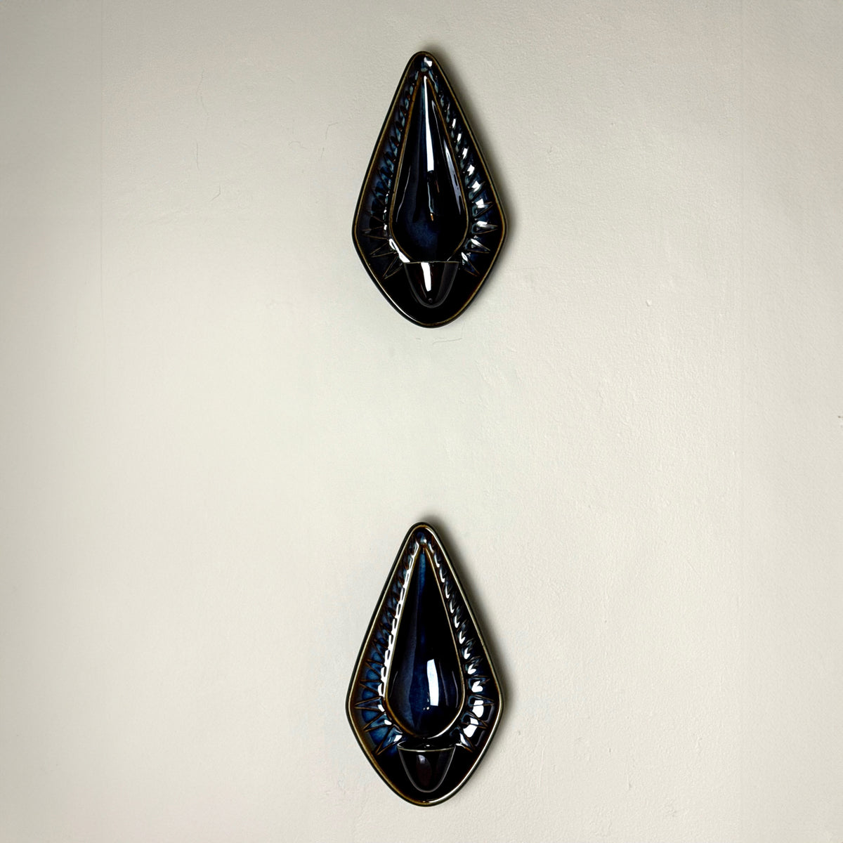 A 1960s stoneware candle holder sconce designed by Einar Johansen for Søholm. Featuring a striking diamond shape with a blue and brown glaze, model 3351, this vintage piece exemplifies Danish mid-century craftsmanship.