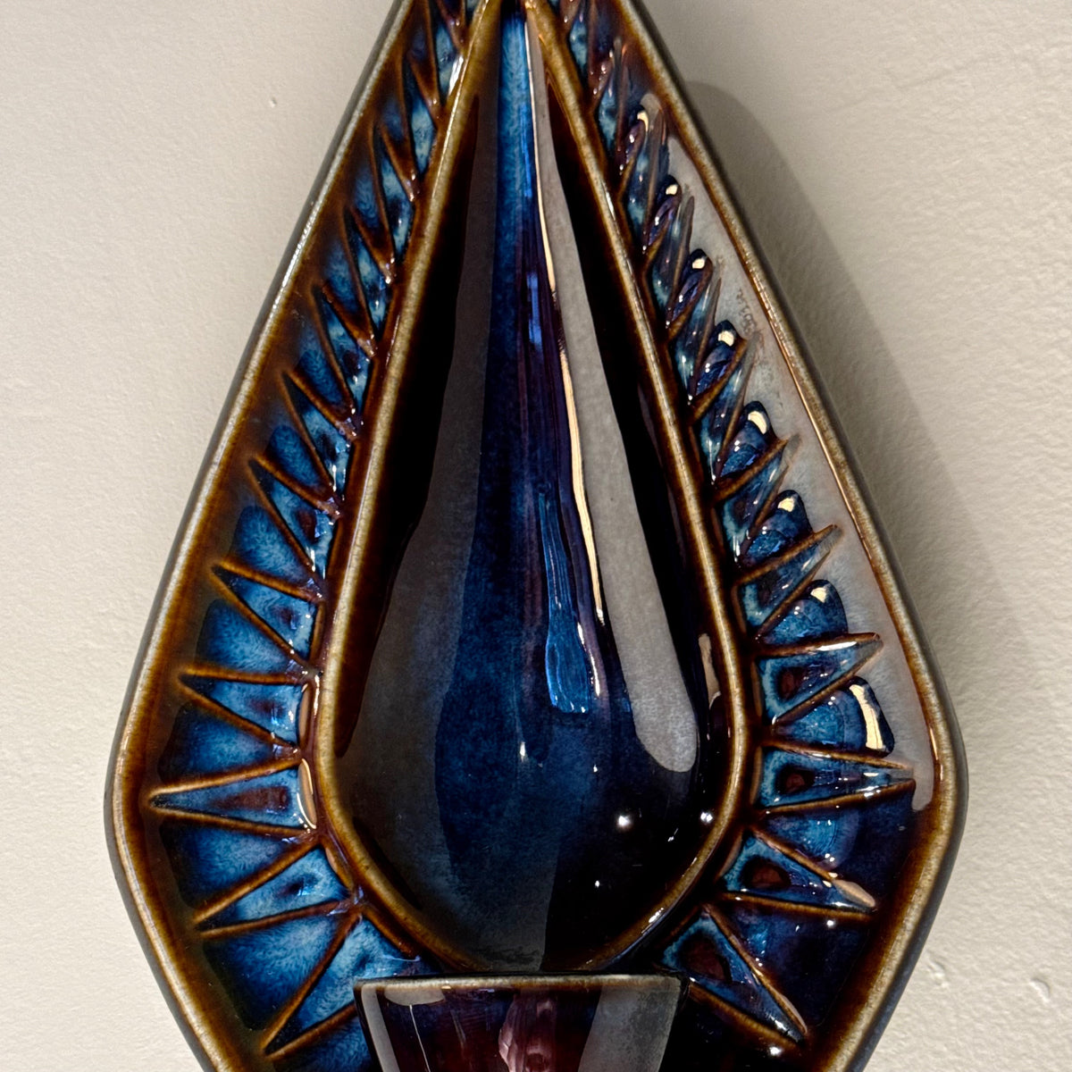 A 1960s stoneware candle holder sconce designed by Einar Johansen for Søholm. Featuring a striking diamond shape with a blue and brown glaze, model 3351, this vintage piece exemplifies Danish mid-century craftsmanship.