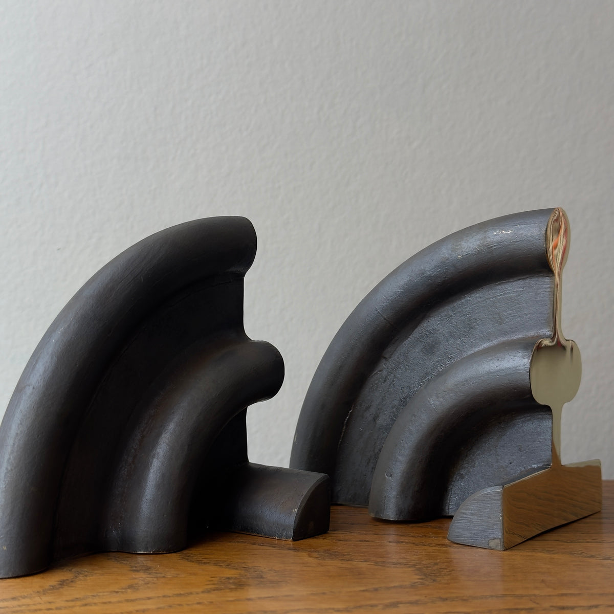 A cast brass bookend named 'Sun,' model 5533, designed by Carl Auböck and made in Vienna. This piece exemplifies modernist design with its sleek and artistic form.