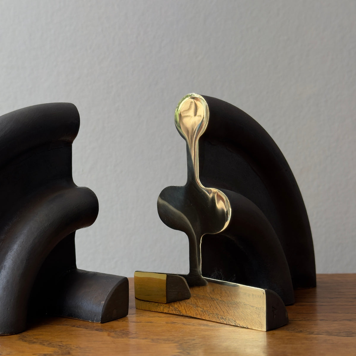 A cast brass bookend named 'Sun,' model 5533, designed by Carl Auböck and made in Vienna. This piece exemplifies modernist design with its sleek and artistic form.