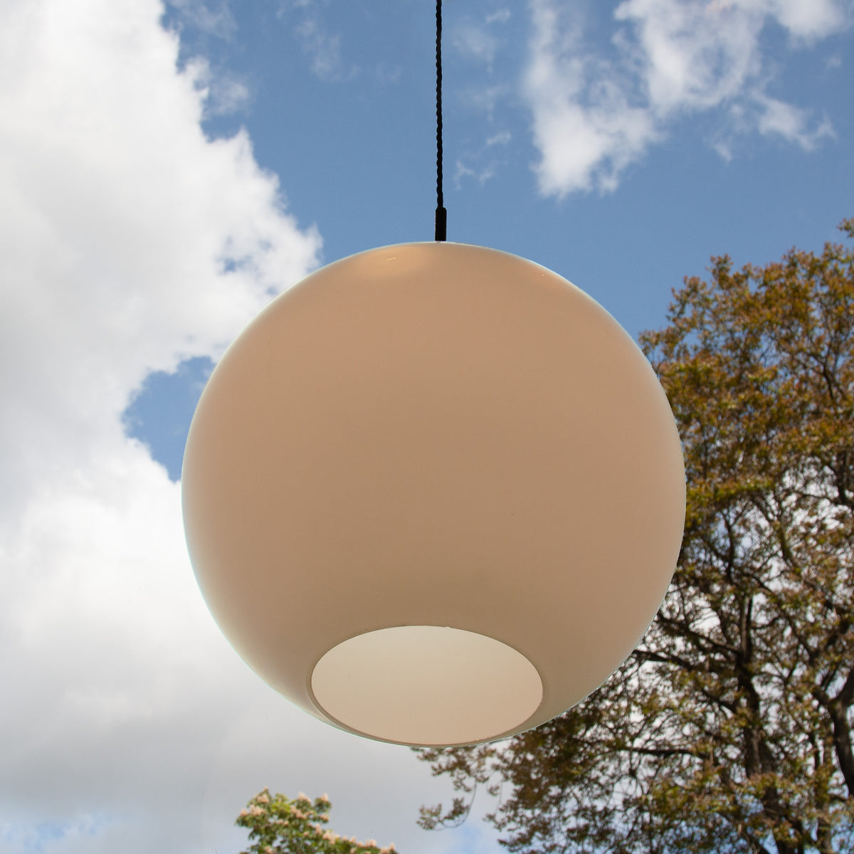 A vintage opal glass globe pendant light, a collaboration between Louis Poulsen and Wilhelm Wohlert. This timeless piece reflects mid-century modern design and is available from Sigmar.