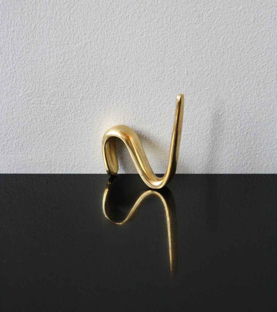 An S-hook designed by Carl Auböck, crafted in the Werkstätte Auböck workshop, Vienna, Austria. Made from brass and designed to be wardrobe-mounted, this piece reflects mid-century Austrian design and craftsmanship.