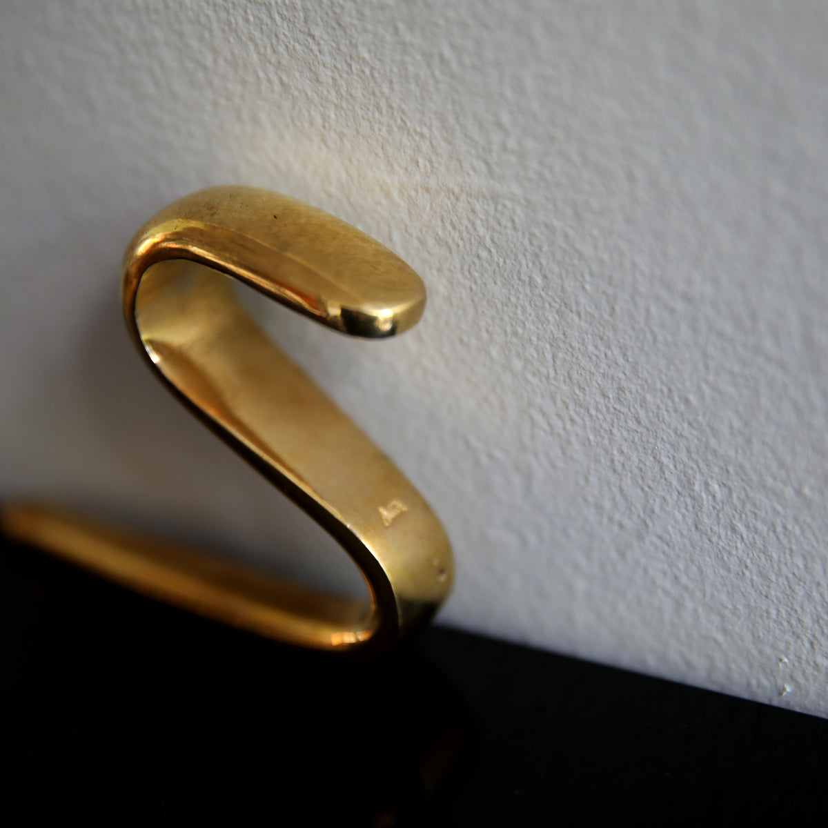 An S-hook designed by Carl Auböck, crafted in the Werkstätte Auböck workshop, Vienna, Austria. Made from brass and designed to be wardrobe-mounted, this piece reflects mid-century Austrian design and craftsmanship.