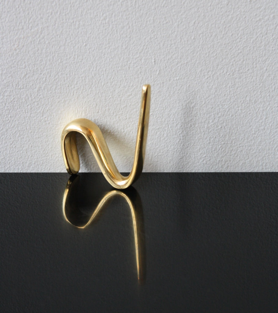 An S-hook designed by Carl Auböck, crafted in the Werkstätte Auböck workshop, Vienna, Austria. Made from brass and designed to be wardrobe-mounted, this piece reflects mid-century Austrian design and craftsmanship.