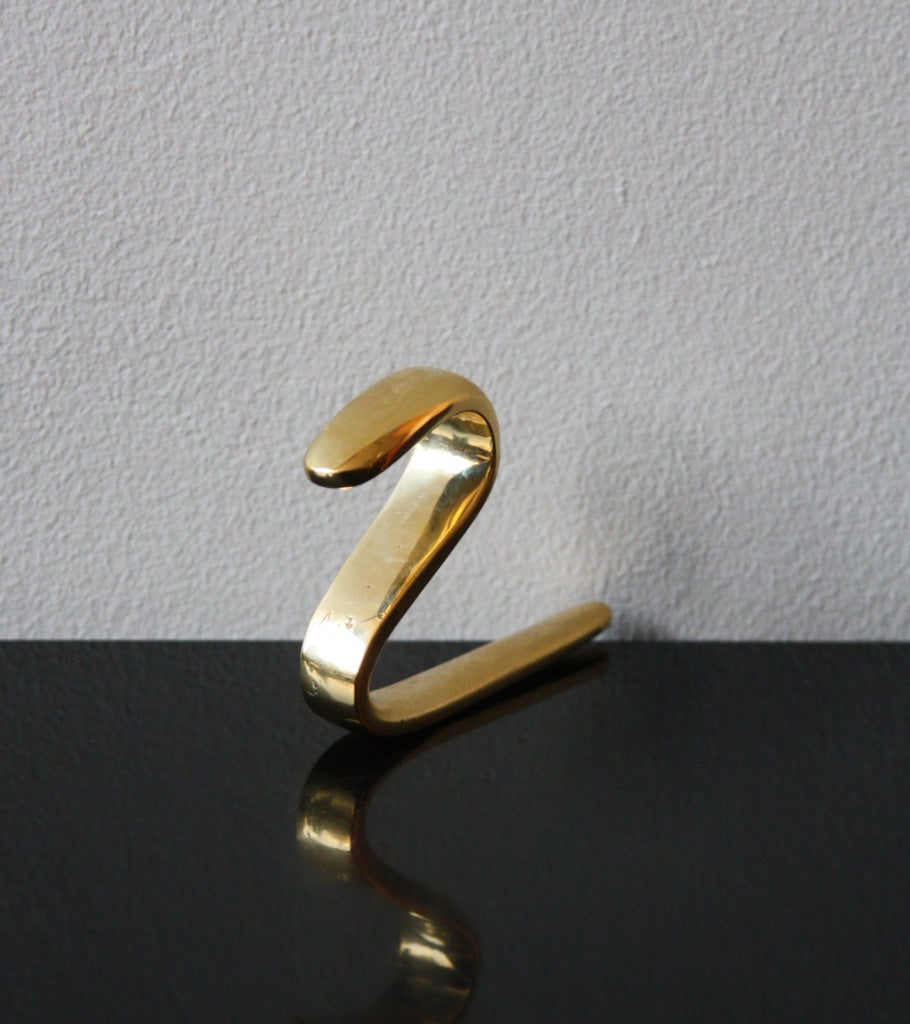 An S-hook designed by Carl Auböck, crafted in the Werkstätte Auböck workshop, Vienna, Austria. Made from brass and designed to be wardrobe-mounted, this piece reflects mid-century Austrian design and craftsmanship.