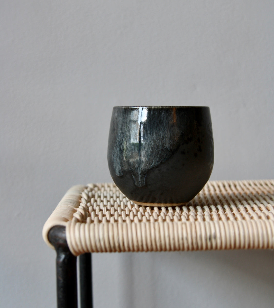 A handcrafted ceramic cup by Kasper Würtz, a Danish ceramicist renowned for his hand-thrown and hand-glazed stoneware. Inspired by Nordic utilitarian crafts and British studio pottery, the design features a balanced inner-outer ratio, subtle concavity, and a glaze that harmoniously blends matte and glossy finishes. Diameter: 7.5 cm, Height: 7.5 cm.