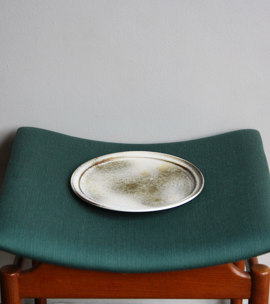 A handcrafted ceramic plate by Aage and Kasper Würtz, Danish studio ceramicists known for their distinctive hand-thrown and hand-glazed stoneware. Inspired by Nordic utilitarian crafts and British studio pottery, the design features a balanced inner-outer ratio, subtle concavity, and a harmonious interplay of matte and glossy glaze. Diameter: 27 cm, Height: 2 cm.