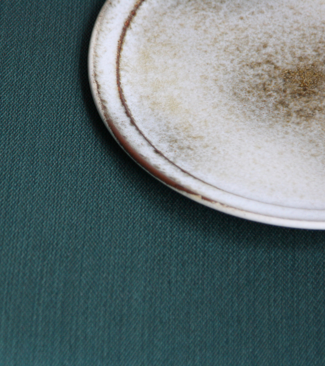 A handcrafted ceramic plate by Aage and Kasper Würtz, Danish studio ceramicists known for their distinctive hand-thrown and hand-glazed stoneware. Inspired by Nordic utilitarian crafts and British studio pottery, the design features a balanced inner-outer ratio, subtle concavity, and a harmonious interplay of matte and glossy glaze. Diameter: 27 cm, Height: 2 cm.