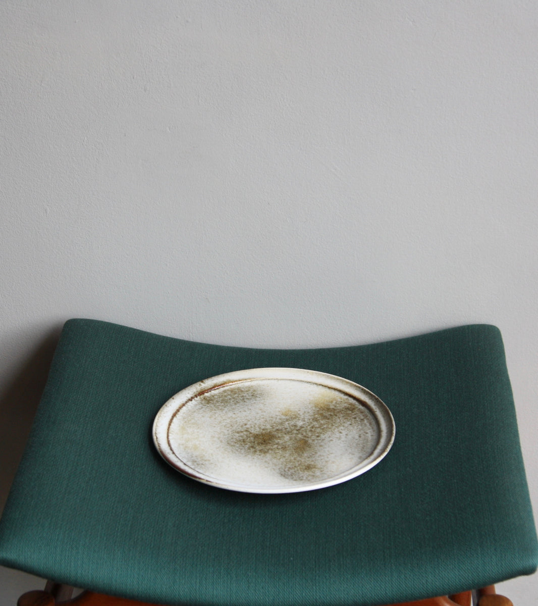 A handcrafted ceramic plate by Aage and Kasper Würtz, Danish studio ceramicists known for their distinctive hand-thrown and hand-glazed stoneware. Inspired by Nordic utilitarian crafts and British studio pottery, the design features a balanced inner-outer ratio, subtle concavity, and a harmonious interplay of matte and glossy glaze. Diameter: 27 cm, Height: 2 cm.