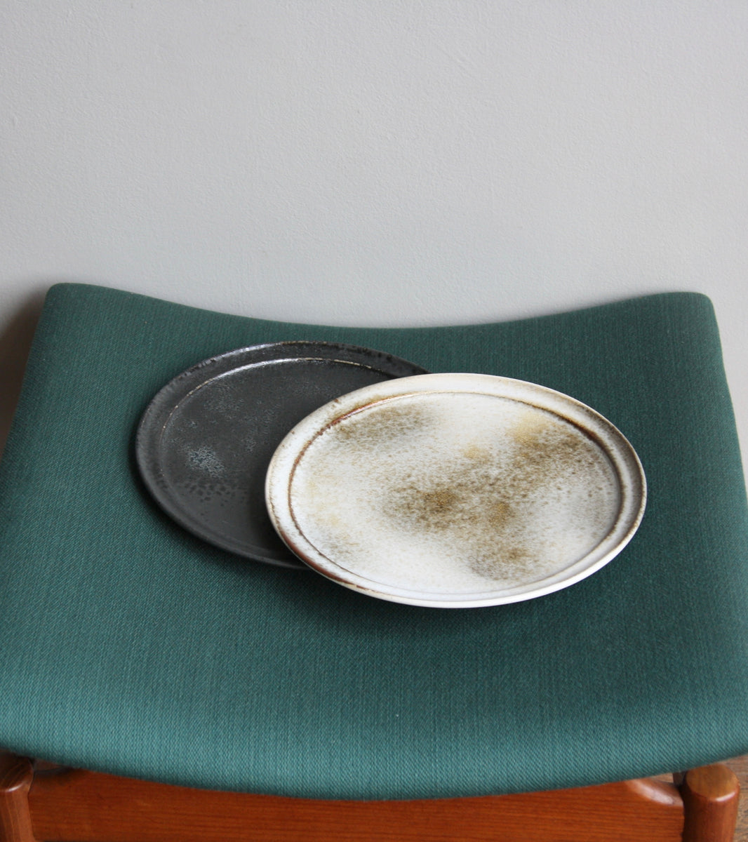 A handcrafted ceramic plate by Aage and Kasper Würtz, Danish studio ceramicists known for their distinctive hand-thrown and hand-glazed stoneware. Inspired by Nordic utilitarian crafts and British studio pottery, the design features a balanced inner-outer ratio, subtle concavity, and a harmonious interplay of matte and glossy glaze. Diameter: 27 cm, Height: 2 cm.