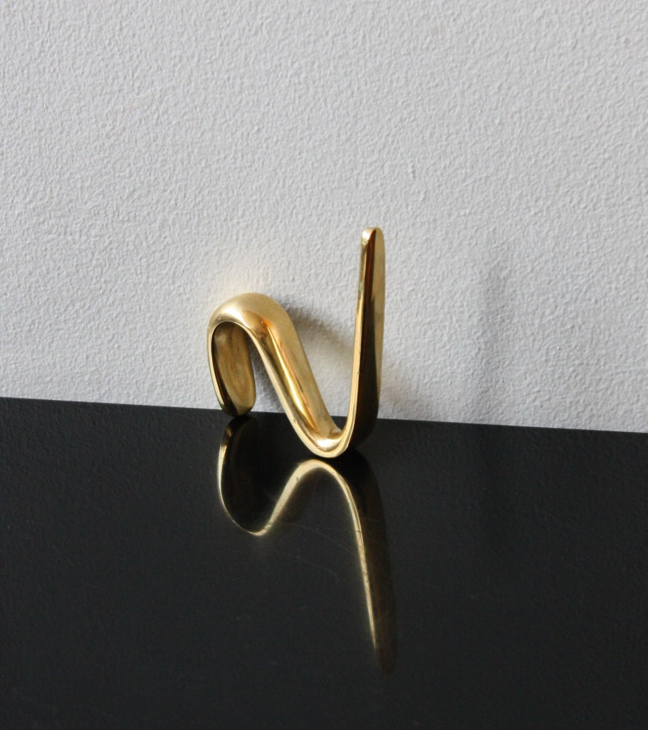 An S-hook designed by Carl Auböck, crafted in the Werkstätte Auböck workshop, Vienna, Austria. Made from brass and designed to be wardrobe-mounted, this piece reflects mid-century Austrian design and craftsmanship.