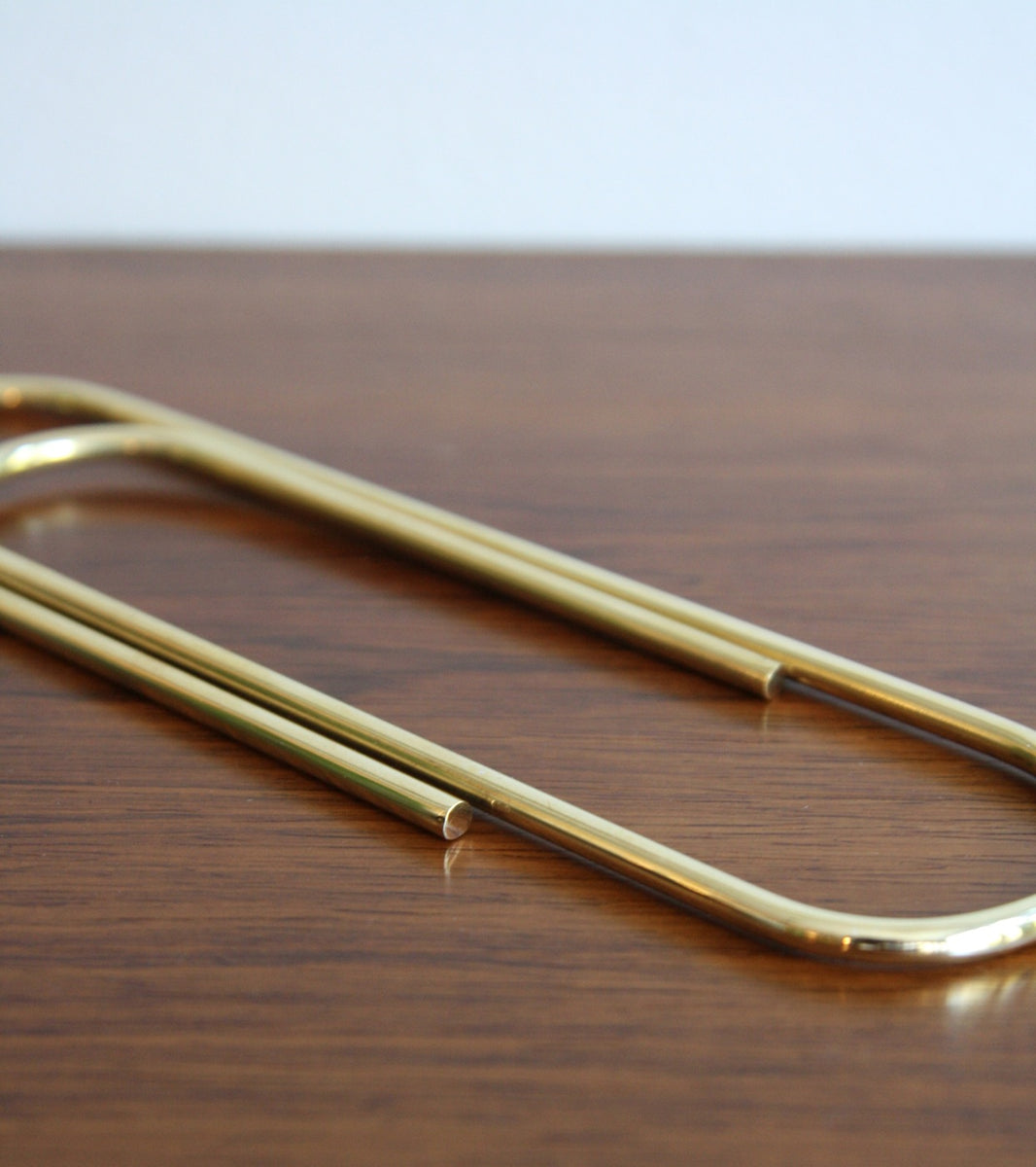 An oversized paper clip designed by Carl Auböck, crafted in brass and available at Sigmar London. This iconic midcentury design piece showcases the playful yet functional style of the Auböck workshop.