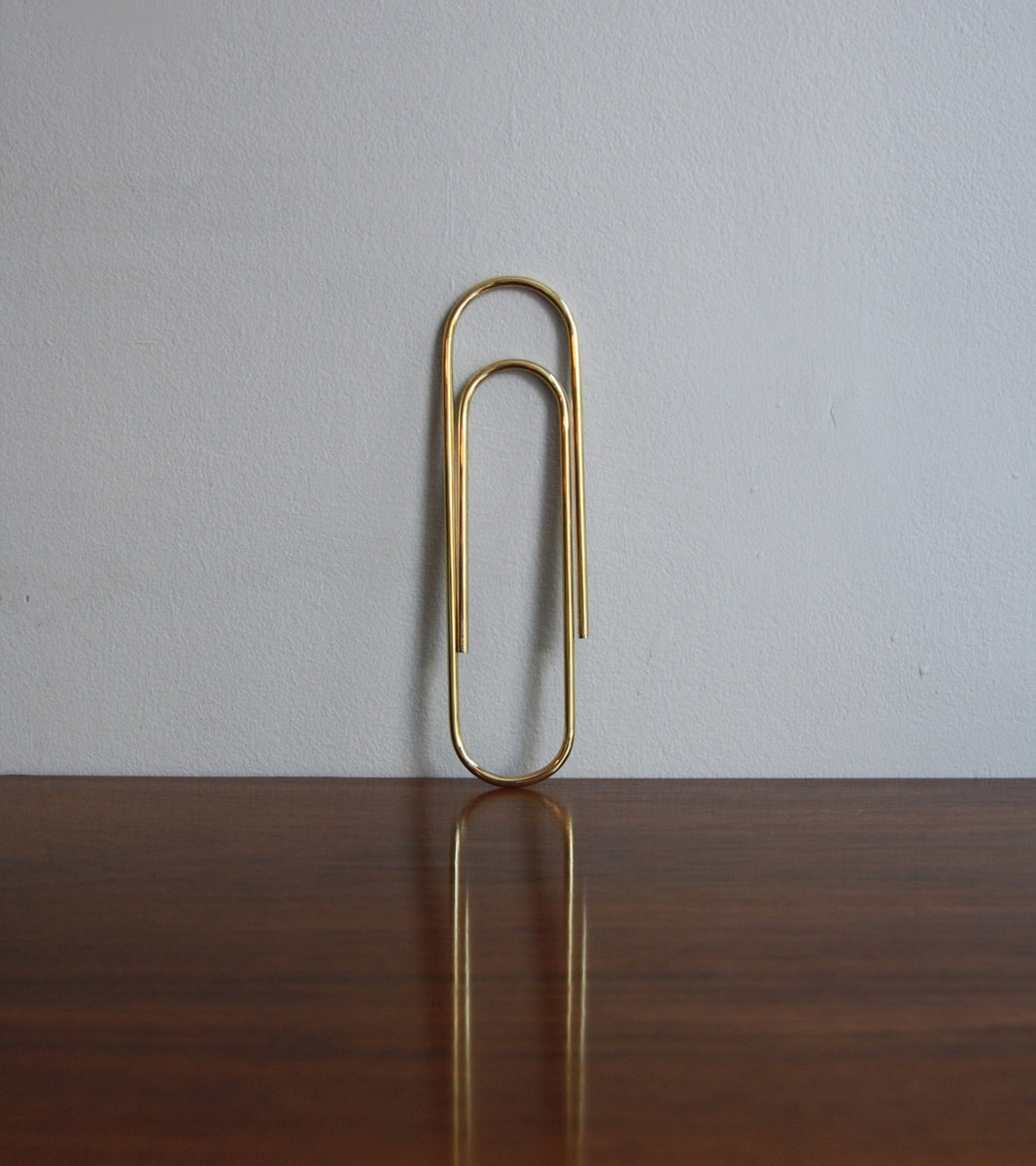 An oversized paper clip designed by Carl Auböck, crafted in brass and available at Sigmar London. This iconic midcentury design piece showcases the playful yet functional style of the Auböck workshop.